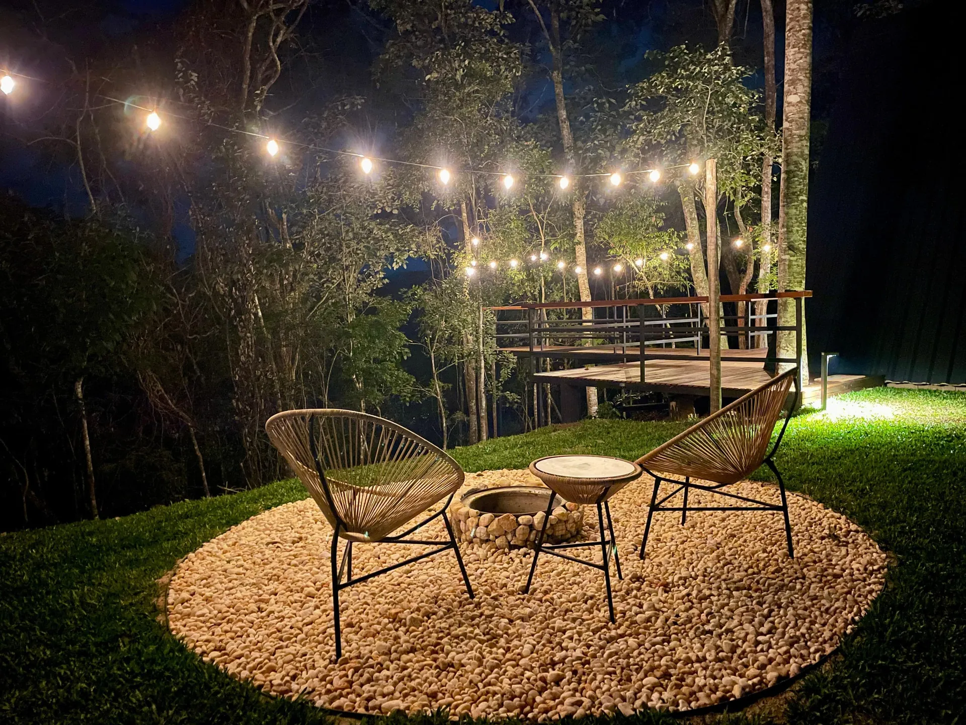 Área do fogo de chão com poltronas sob o varal de luzes
