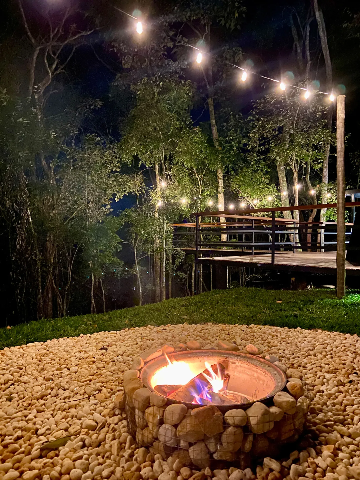 Fogo aceso no fire pit de pedras, à noite